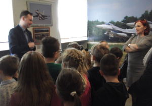 Dzieci oglądają zdjęcia i modele samolotów oraz strój i fotel pilota.
